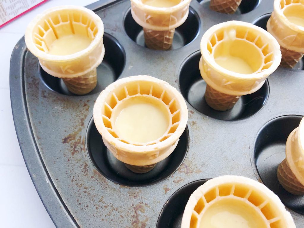 ice cream cones sitting in a metal cupcake tin