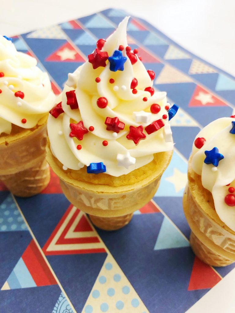 ice cream cone cupcakes on a patriotic themed sheet of scrap book paper & topped with red white and blue star shaped sprinkles