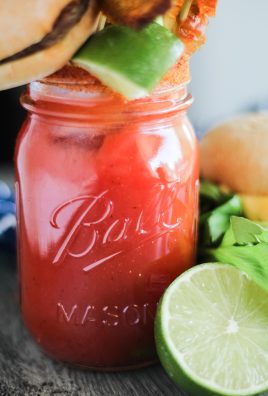 ultimate bloody mary in a Mason jar with a variety of skewered appetizers for garnish