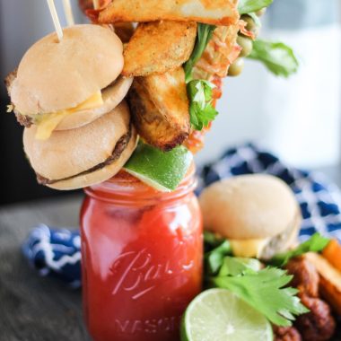 ultimate bloody mary in a Mason jar with a variety of skewered appetizers for garnish