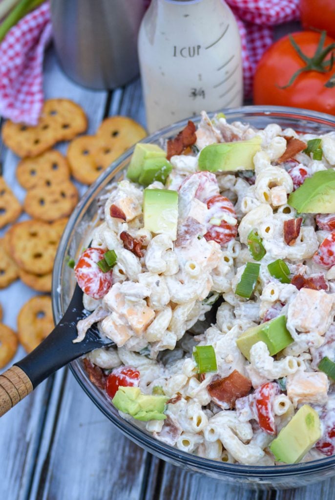 a scoop of chicken club pasta salad shown taken from a glass bowl