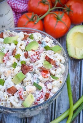 chicken club pasta salad in a glass mixing bowl surrounded by fresh produce
