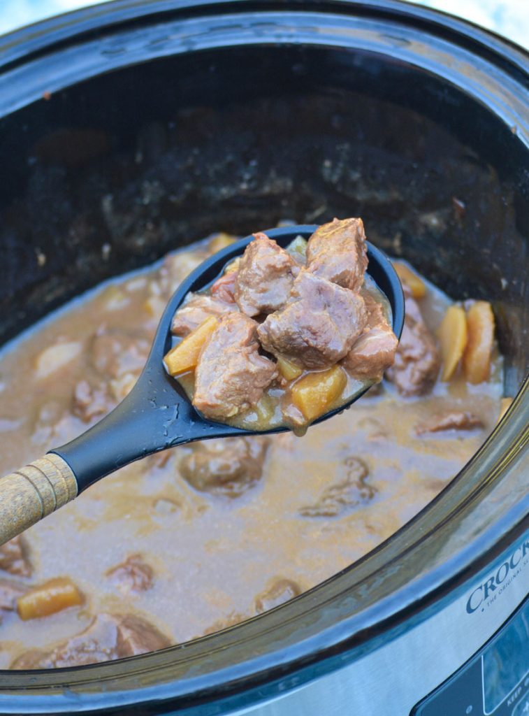 a spoon holding a loft a scoop of crockpot steak teriyaki with pineapple