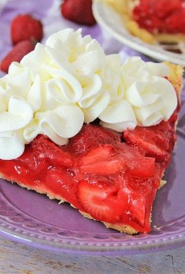 a slice of strawberry jello pie on a purple plate, topped with dollops of whipped cream