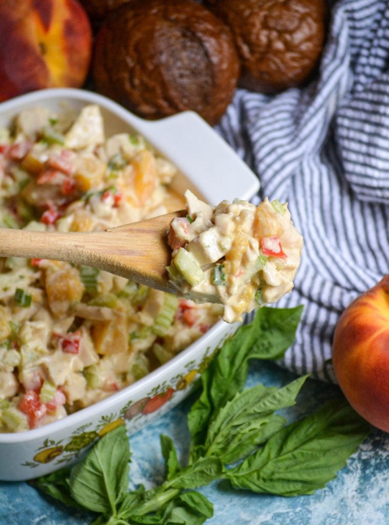 peach basil chicken salad in a white square pyrex dish with a wooden spoon