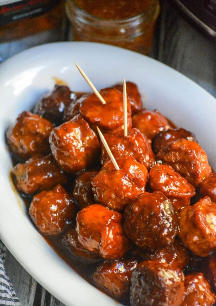 peach bourbon meatballs shown in a white serving dish with toothpicks stuck in them