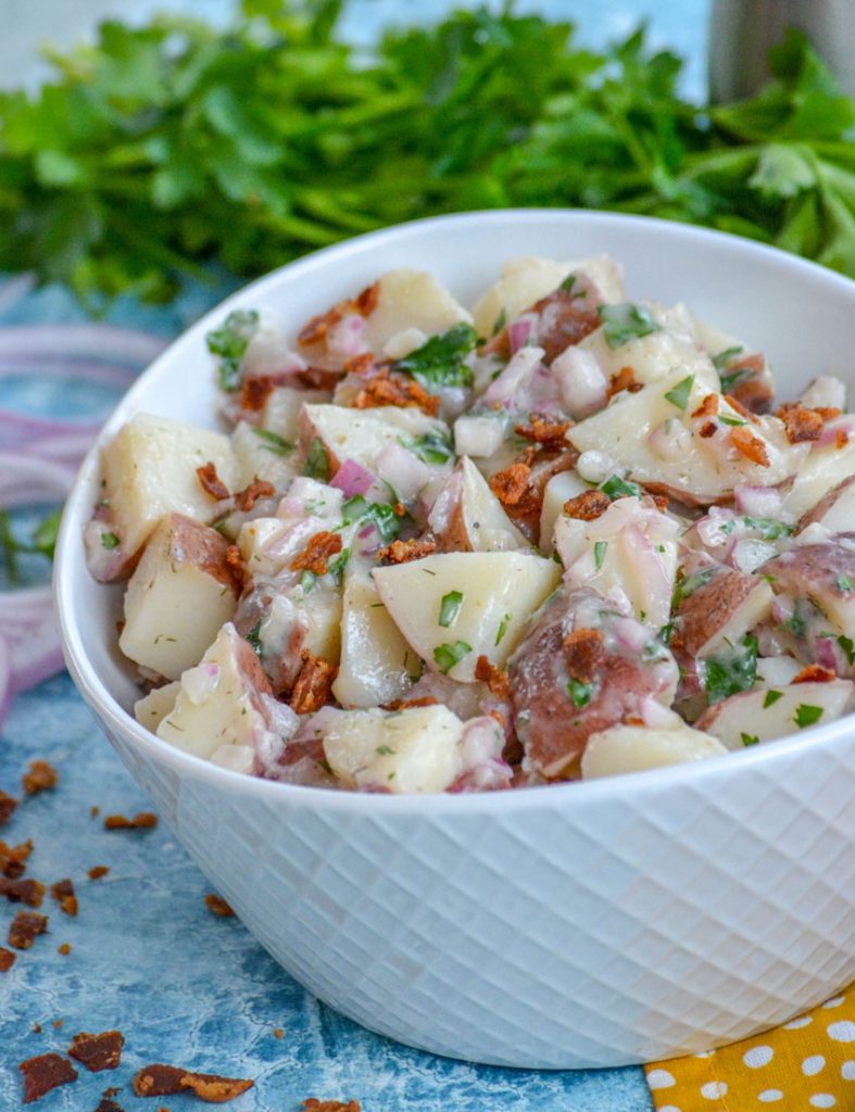 salt potato salad served in a white bowl set on a yellow cloth napkin