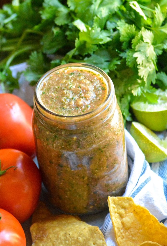 smoked salsa in a glass mason jar surrounded by fresh produce
