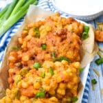 sweet corn and cheddar cheese fritters on a brown parchment paper lined white serving platter