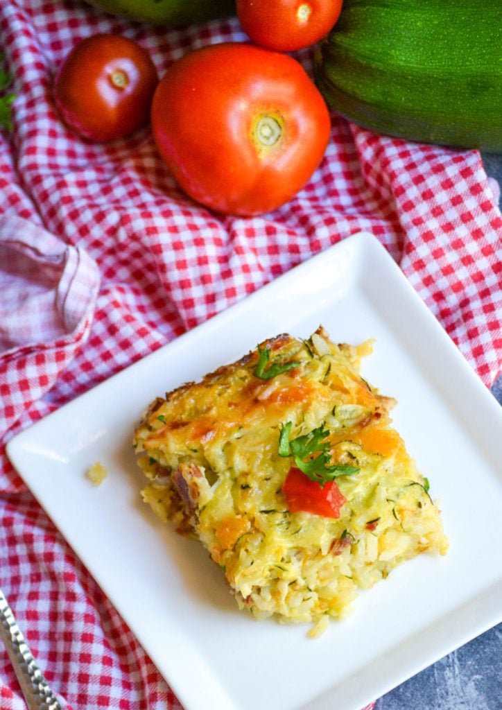 a slice of Zucchini Rice Casserole with bacon shown on square white appetizer plate