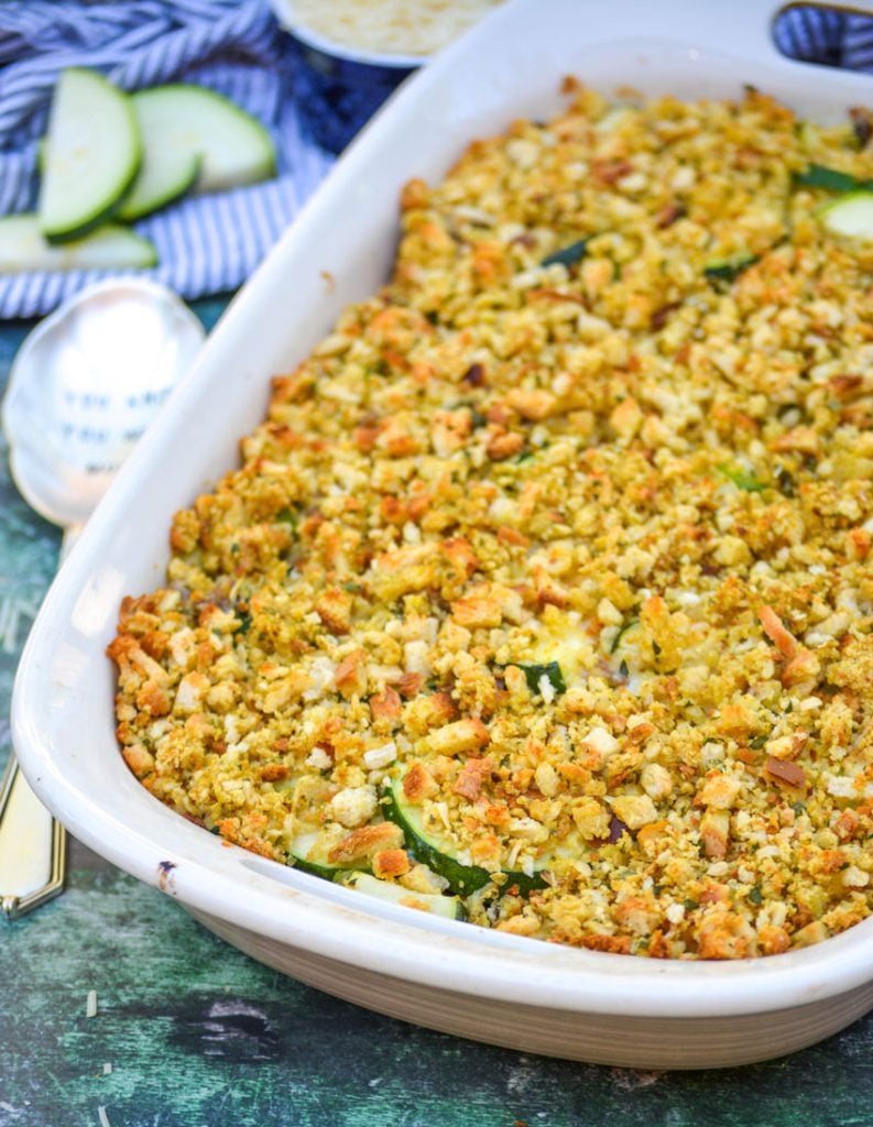 sausage & zucchini casserole in an oval dish with a serving spoon beside it