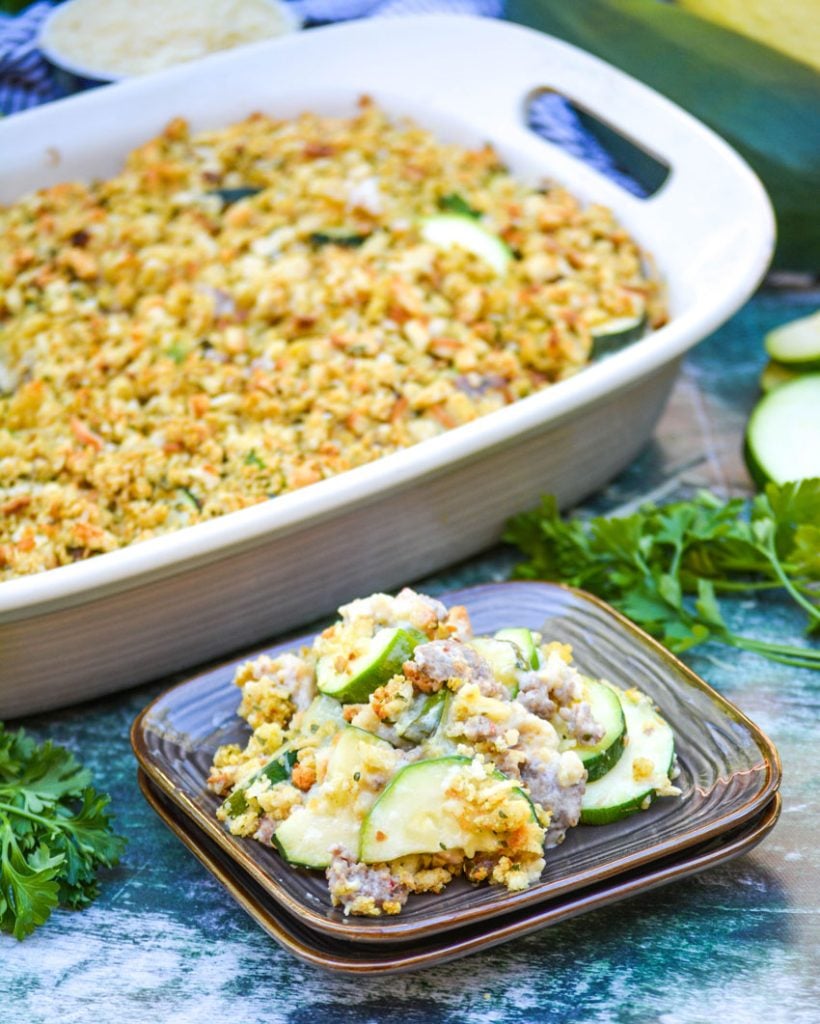 zucchini & sausage casserole shown served on brown square appetizer plates