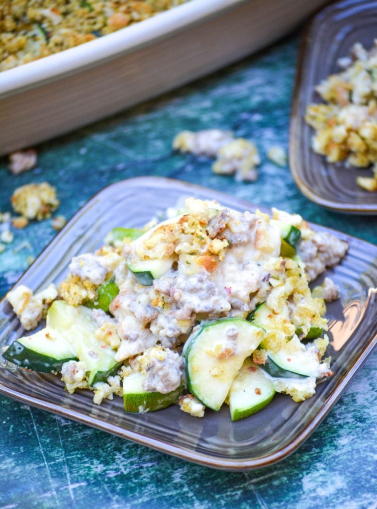 zucchini & sausage casserole shown served on brown square appetizer plates