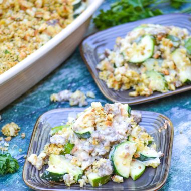 zucchini & sausage casserole shown served on brown square appetizer plates