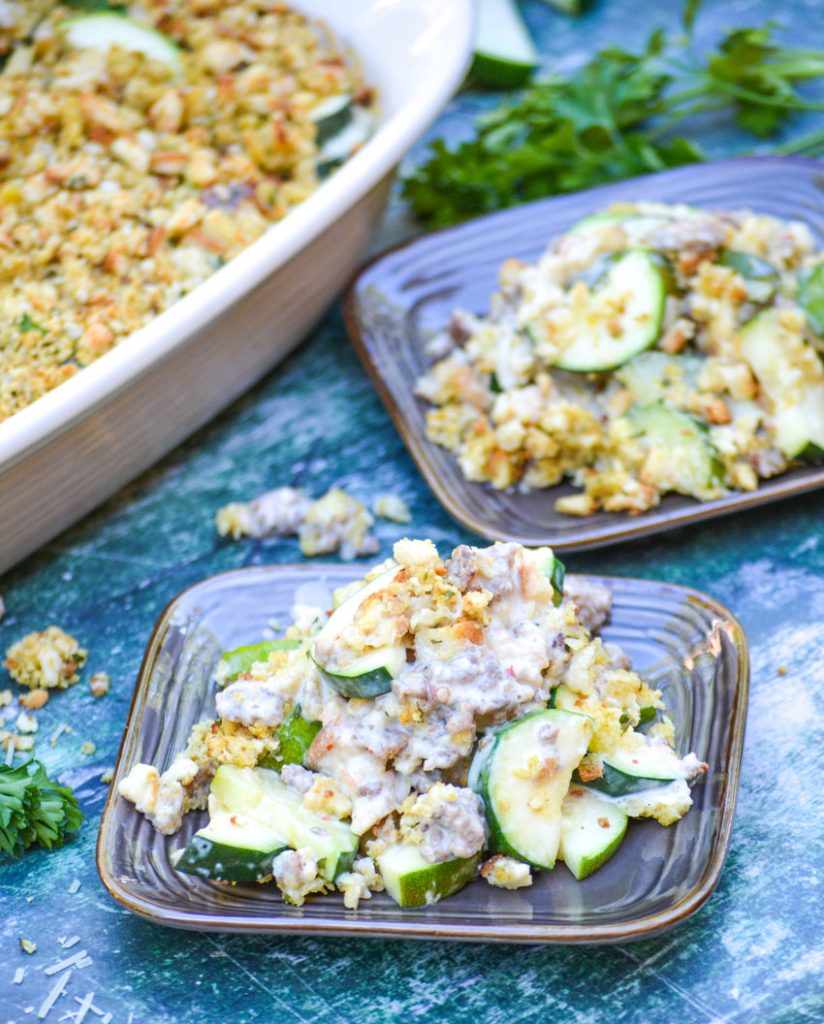 zucchini & sausage casserole shown served on brown square appetizer plates