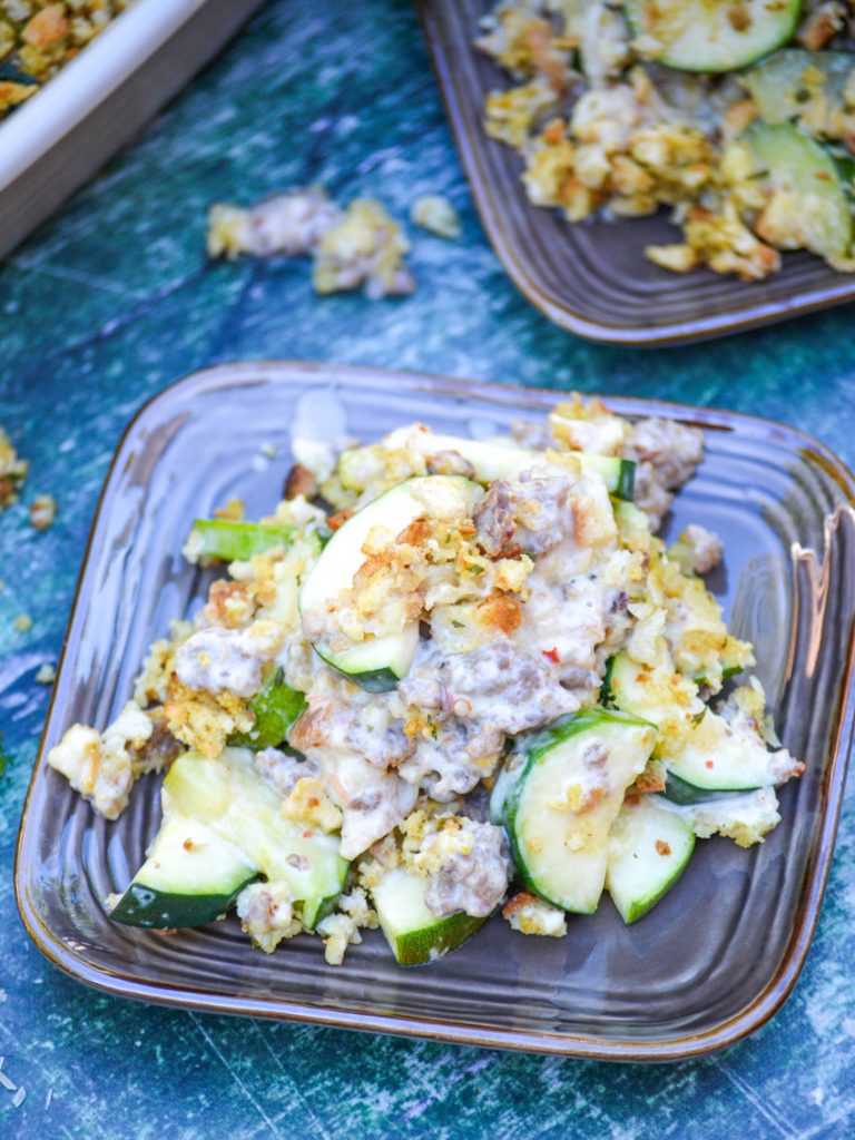 zucchini & sausage casserole shown served on brown square appetizer plates