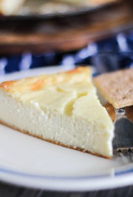a slice of new york style cheesecake on a blue rimmed white plate