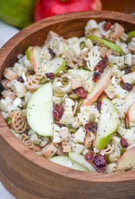 fall harvest pasta salad in a large wooden bowl with fresh apples in the background