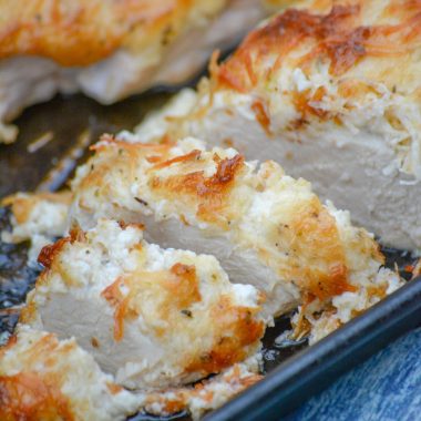 mayo parmesan crusted chicken shown sliced on a baking sheet