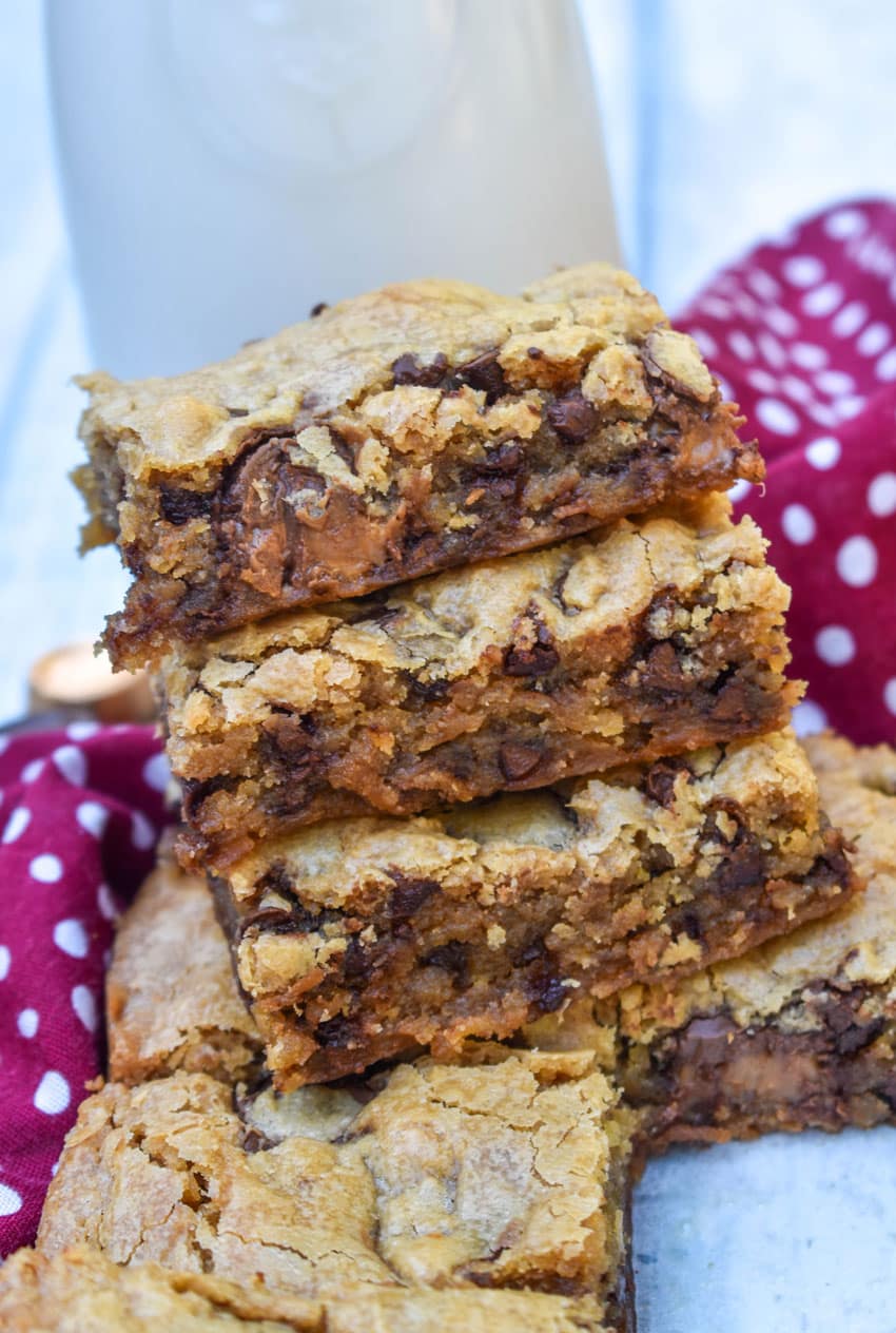 squares of rolo chocolate chip blondies stacked on a wooden table