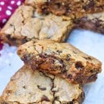 two squares of rolo chocolate chip blondies stacked on a wooden table