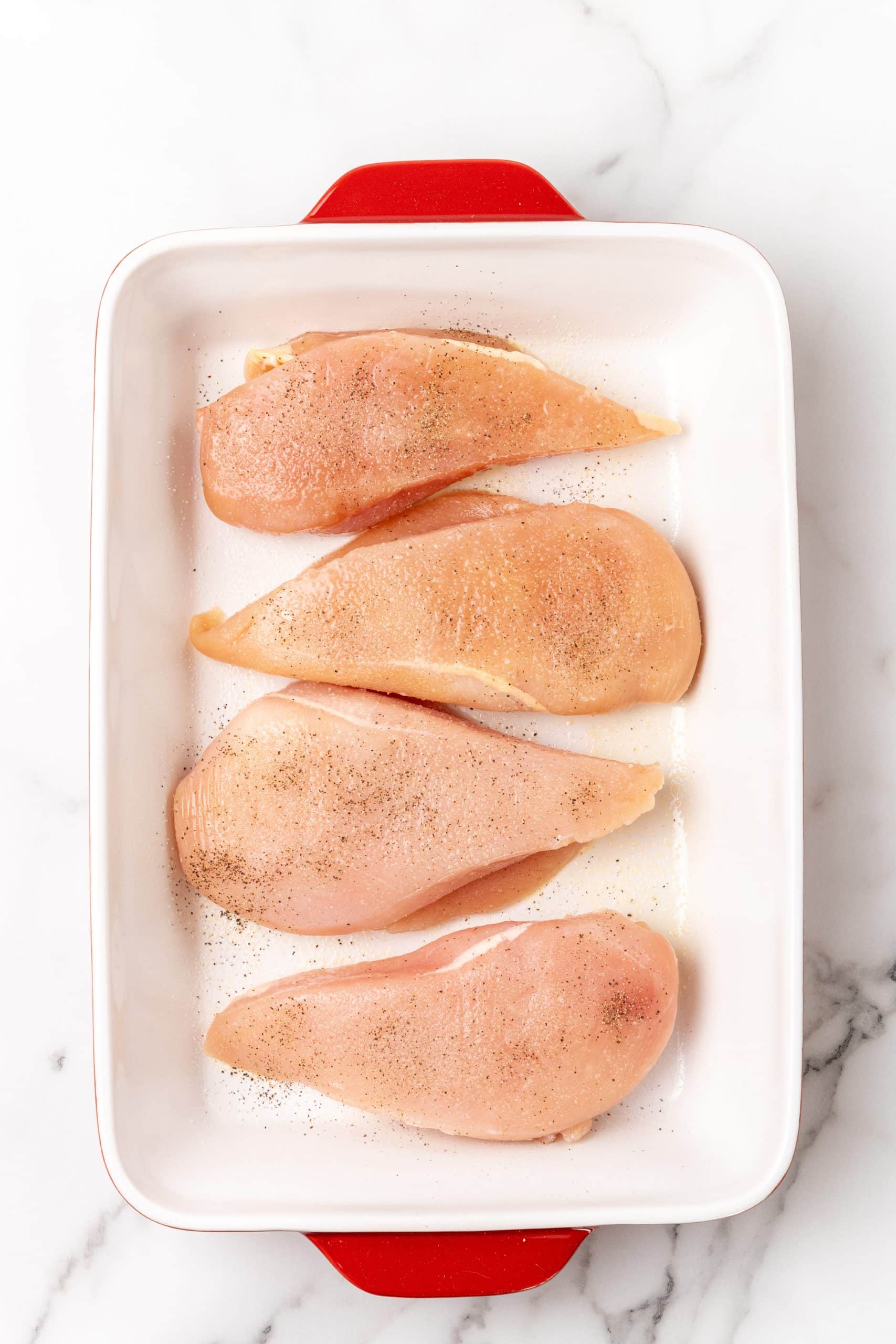 boneless skinless chicken breasts in a white baking dish