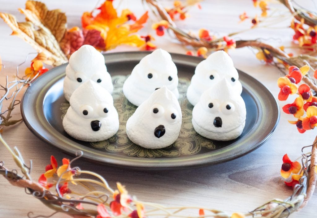 Boo Egg White Meringue Cookies sit on a black platter with Fall colored decor in the background