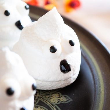 Boo Egg White Meringue Cookies sit on a black platter with Fall colored decor in the background