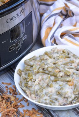 slow cooker green bean casserole served in a white bowl with a crockpot in the background