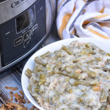 slow cooker green bean casserole served in a white bowl with a crockpot in the background