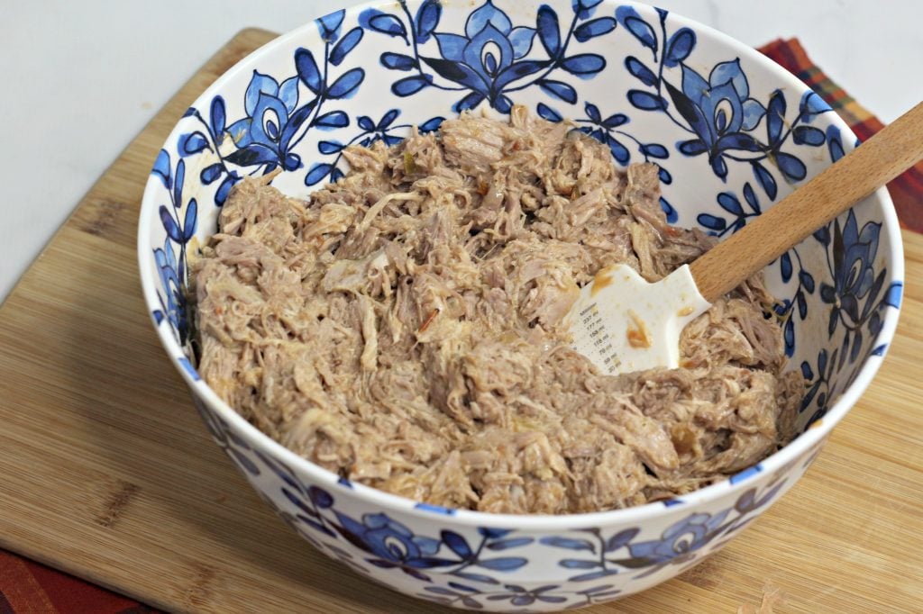 shredded pork filling being mixed in a large bowl for instant pot tamales