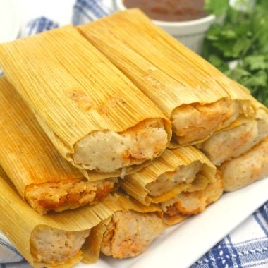 pork tamales stacked on a white serving plate