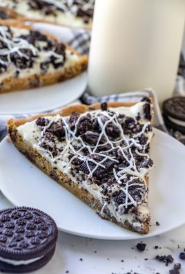 slices of cookies and cream dessert pizza served on white dessert plates with a glass of milk in the background