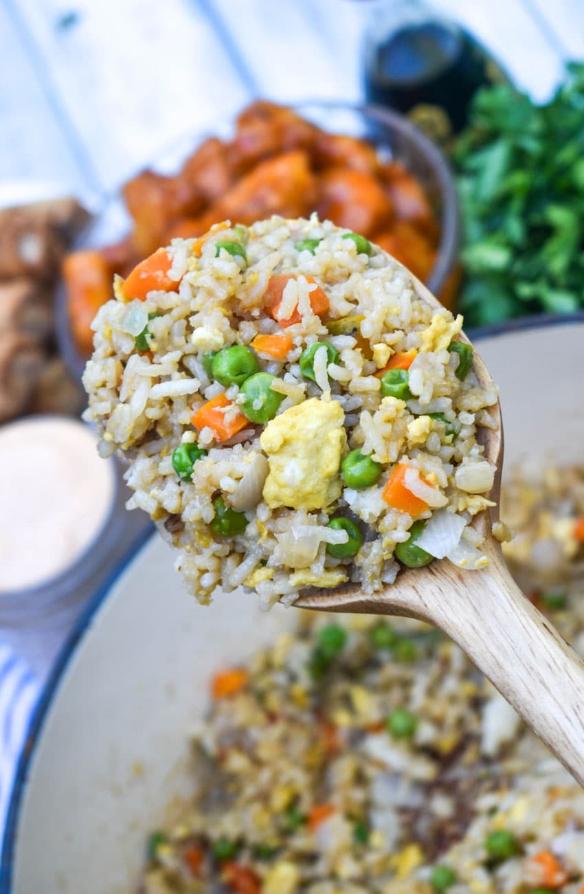 a wooden spoon holding up a scoop of copycat panda express fried rice