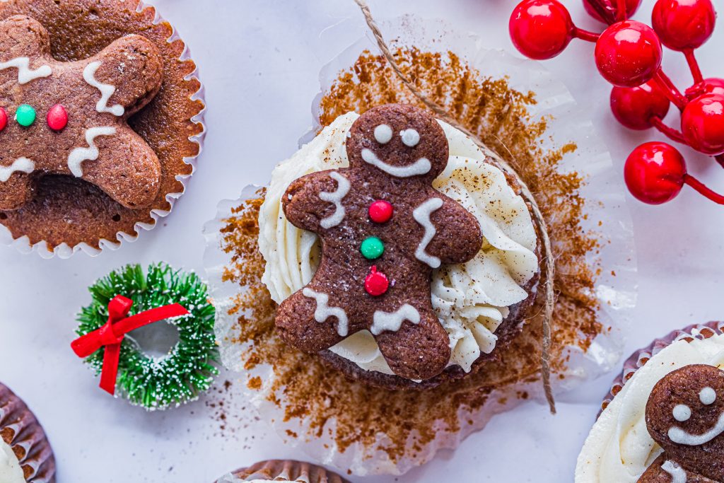 gingerbread cupcakes with spiced butter cream are shown topped with frosted gingerbread cookies