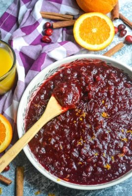 Instant pot cranberry sauce shown in a large shallow white serving dish with a wooden spoon for serving