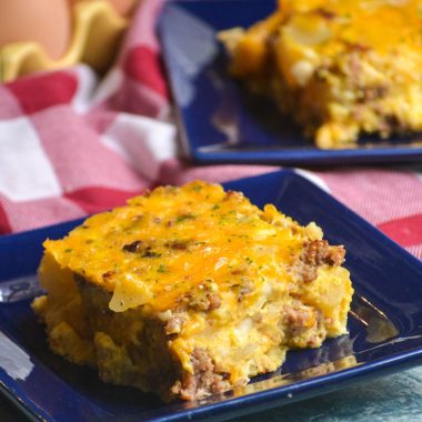 slices of Amish breakfast casserole shown on dark blue square appetizer plates