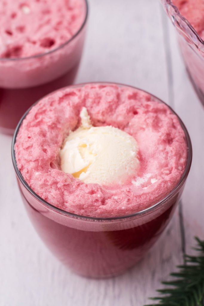 glasses filled with bright red santa snowball punch with a scoop of vanilla ice cream floating in each