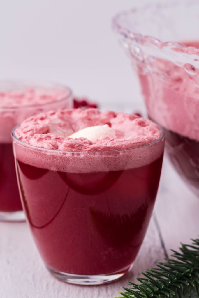 glasses filled with bright red santa snowball punch with a scoop of vanilla ice cream floating in each