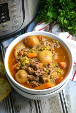 instant pot beef stew served in a white bowl with a pressure cooker shown in the background