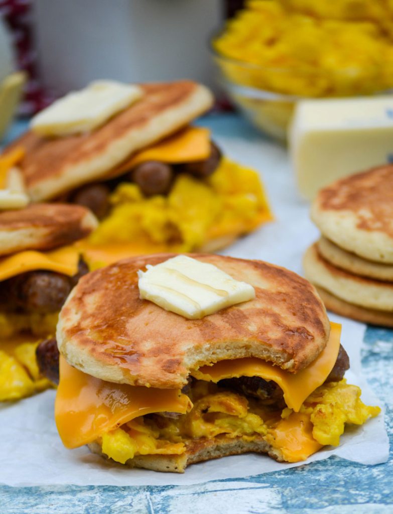 sausage egg and cheese pancake sandwiches shown topped with pats of butter