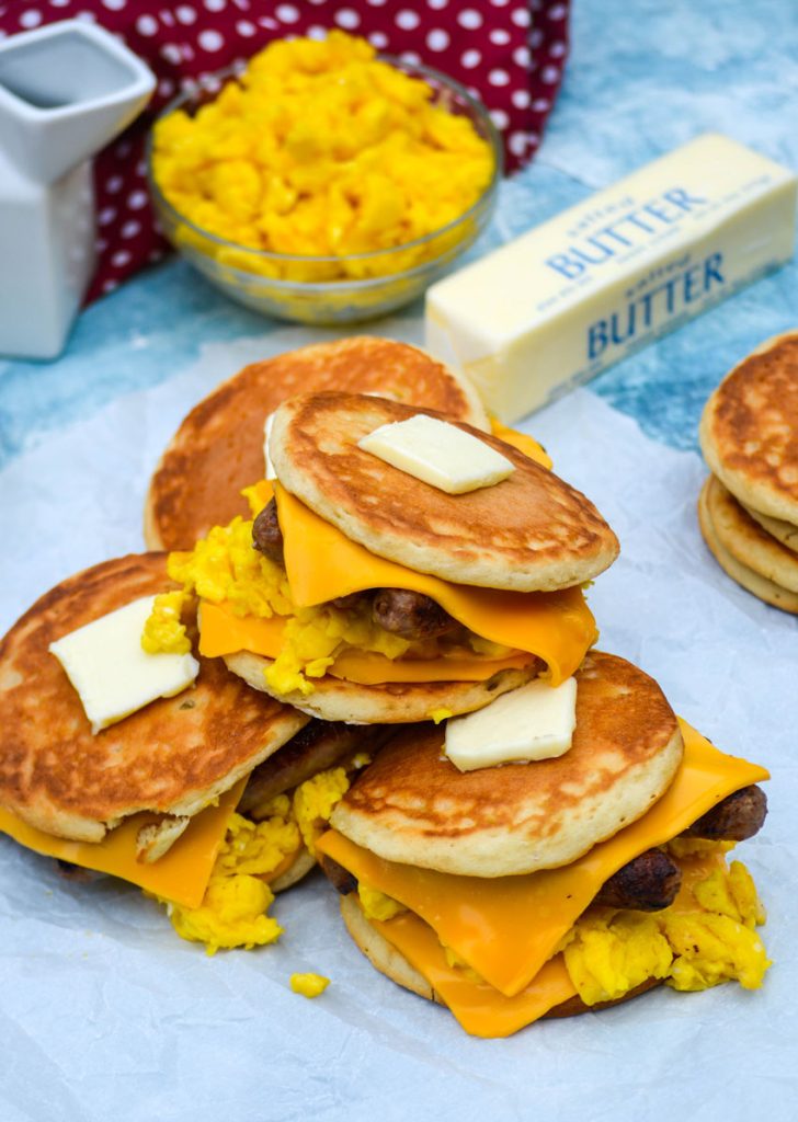 pancake sandwiches piled together, shown topped with pats of butter