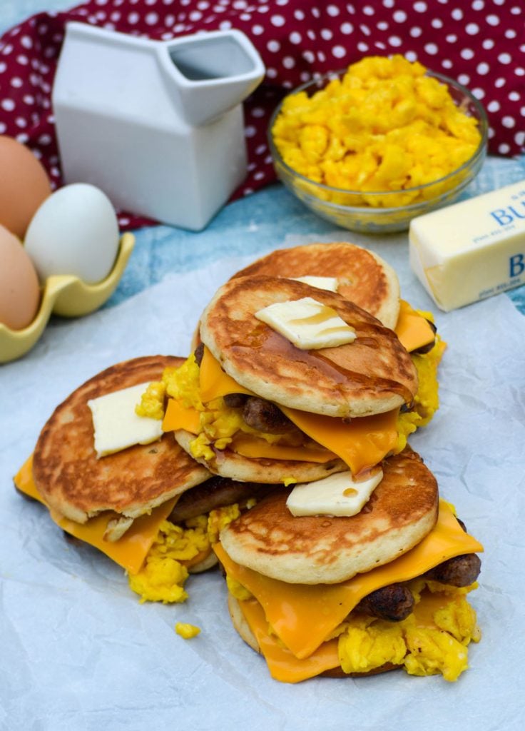 sausage egg and cheese pancake sandwiches shown topped with pats of butter