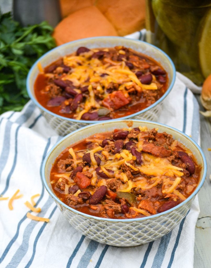 two bowls of cheeseburger chili topped with melted cheddar cheese