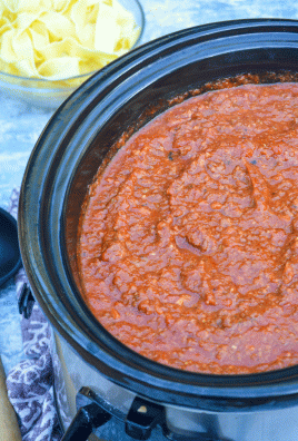 homemade bolognese sauce shown cooked and ready in the black bowl of a slow cooker