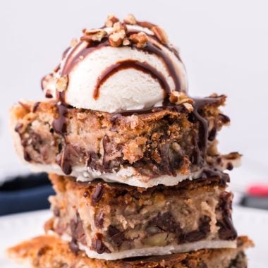 toll house cooking pie bars stacked and topped with a scoop of ice cream and chocolate syrup drizzle