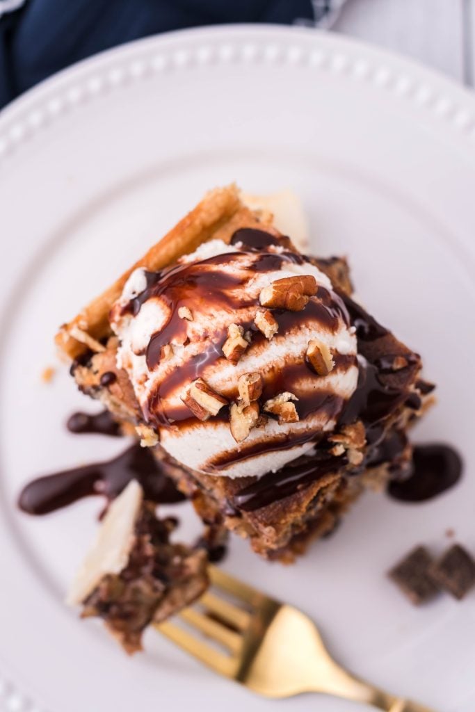 toll house cooking pie bars stacked and topped with a scoop of ice cream and chocolate syrup drizzle