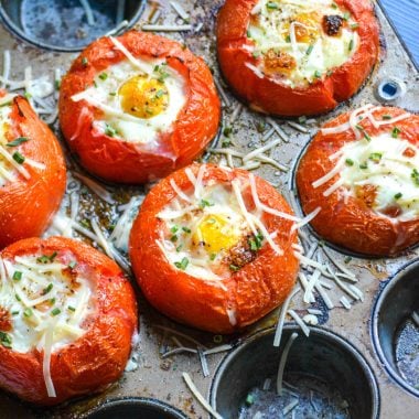 egg stuffed baked tomatoes shown in a muffin tin pan