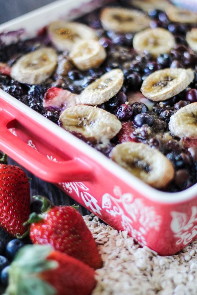 a close up of banana berry breakfast bake in a red square baking dish