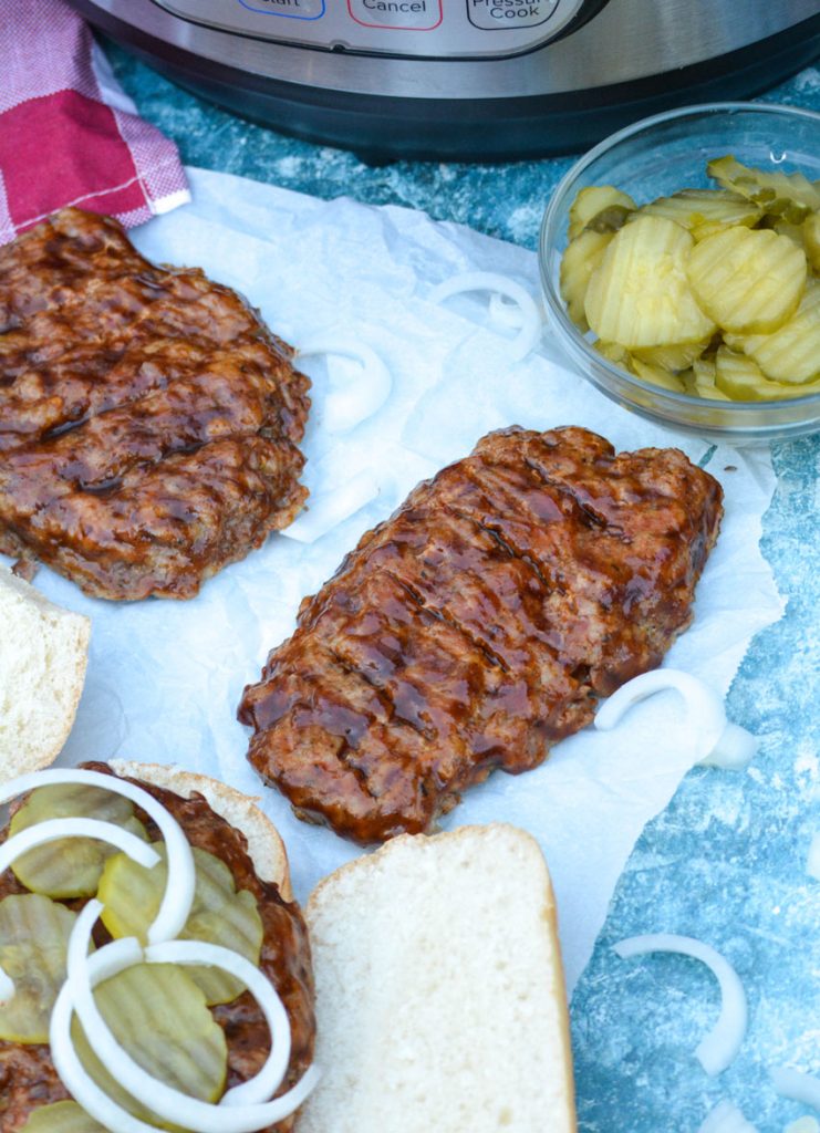 barbecue basted mock rib pork patties are shown on parchment paper in front of an Instant Pot